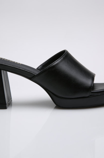 Mules noires à talons de Mode Grande Taille présentant un talon épais et solide et un design à bout ouvert sur un fond blanc uni. Mode Grande taille