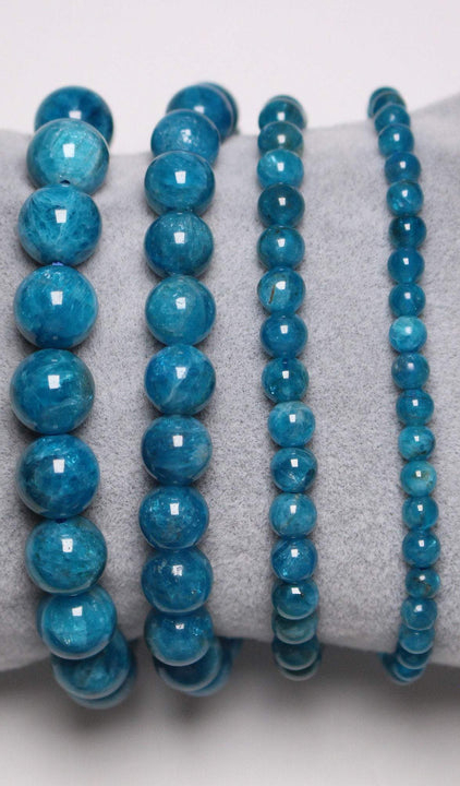 Quatre bracelets apatite bleue élégamment présentés sur un coussin gris, incarnant l'allure Mode Grande Taille. Mode Grande taille