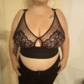 Une personne porte la Bralette Morgon en noir et un pantalon noir de Mode Grande Taille alors qu'elle se tient debout devant une porte de couleur claire. Mode Grande taille