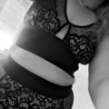 Personne portant la Bralette Morgon, avec de la dentelle noire et des détails découpés, posant à l'intérieur. L'image est en noir et blanc, mettant en valeur l'élégance de Mode Grande Taille.
 Mode Grande taille