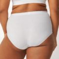 Une personne portant des sous-vêtements blancs taille haute de la collection Lot de 2 culottes control maxi Sloggi de Mode Grande Taille, montrant la vue arrière de la taille vers le bas. Mode Grande taille