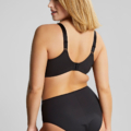 Une femme porte le Soutien-gorge balconnet Esmé Ziggy et le sous-vêtement taille haute assorti de la collection Mode Grande Taille, mettant en valeur ses profils arrière et latéraux avec une expression confiante. Mode Grande taille