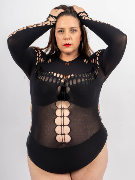 Une femme vêtue d'un body noir à motifs pose avec les deux mains sur la tête sur un fond blanc uni. Mode Grande taille