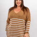 Femme aux cheveux longs souriante, portant un pull rayé marron et blanc avec un col en V sur un fond uni. Mode Grande taille