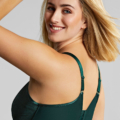 Une femme aux cheveux blonds sourit à la caméra, présentant le Soutien gorge emboîtant Illuminate en vert avec bretelles réglables, vu de dos et de côté. Mode Grande taille