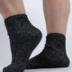 Deux pieds portant des chaussettes noires scintillantes sont représentés sur un fond uni. Mode Grande taille