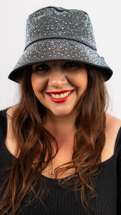 Femme avec un chapeau à motifs et du rouge à lèvres rouge, souriant sur un fond blanc uni. Mode Grande taille