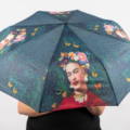 Personne tenant un parapluie coloré avec un portrait artistique d'une femme et des papillons dessus. Mode Grande taille