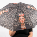 Personne tenant un parapluie avec un portrait de Frida Kahlo et un fond à motifs. Mode Grande taille