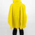 Personne en imperméable jaune et capuche, regardant ailleurs, avec des bottes noires sur fond blanc. Mode Grande taille