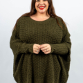 Femme en pull tricoté vert souriant sur fond blanc. Mode Grande taille