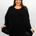 Personne souriante portant un pull en tricot noir sur un fond blanc uni. Mode Grande taille