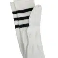 Chaussettes hautes jusqu'aux cuisses, blanches avec trois bandes noires en haut, posées à plat sur un fond blanc. Mode Grande taille