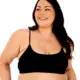 Une femme souriante aux longs cheveux noirs porte la Brassière côtelée en noir, debout sur un fond blanc. Mode Grande taille