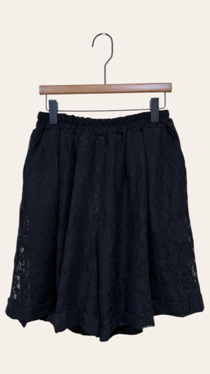Blazer en dentelle noire dit "Blazer en dentelle" avec une ceinture élastique, présenté sur un cintre en bois sur un fond uni. Mode Grande taille