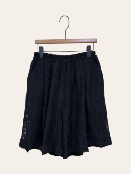 Blazer en dentelle noire dit "Blazer en dentelle" avec une ceinture élastique, présenté sur un cintre en bois sur un fond uni. Mode Grande taille