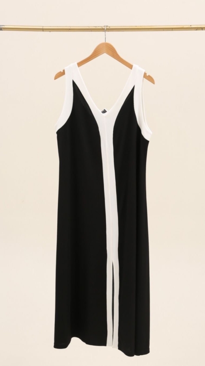 Robe imprimée noire et blanche sans manches, ornée d'un liseré blanc et d'une bande verticale blanche, présentée sur un cintre en bois. Mode Grande taille