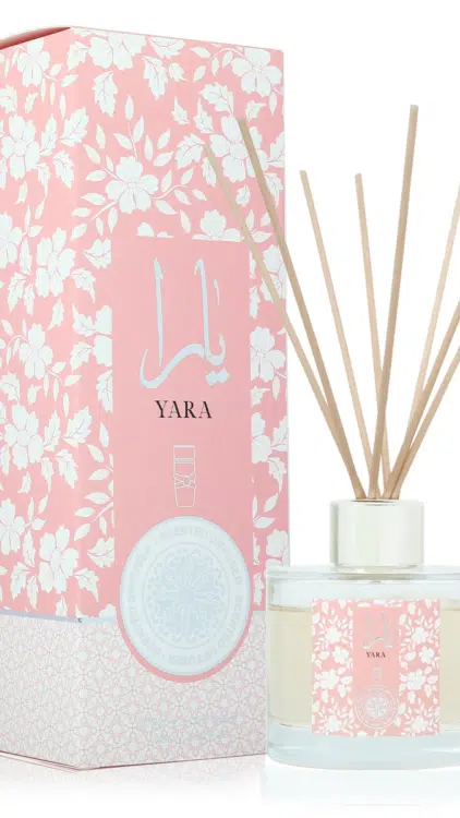 Le diffuseur Yara Rose présente une boîte rose à motifs floraux étiquetée « YARA » à côté d'un diffuseur à roseaux en verre avec des bâtons en bois. Mode Grande taille