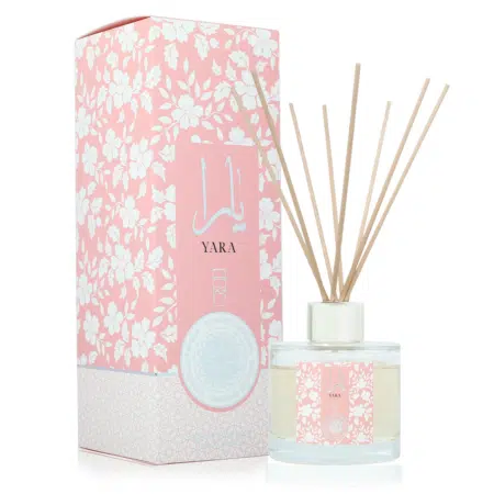 Le diffuseur Yara Rose présente une boîte rose à motifs floraux étiquetée « YARA » à côté d'un diffuseur à roseaux en verre avec des bâtons en bois. Mode Grande taille