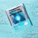 Un emballage de Masque hydratant pour les yeux pour une hydratation en profondeur repose sur une surface texturée de couleur turquoise. Mode Grande taille