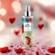 Une bouteille de Brume Poire dans un body splash amoureux sur une surface rose avec des cœurs rouges et des lumières bokeh en arrière-plan. Mode Grande taille