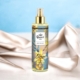 Une bouteille de lotion corporelle Queen's Peach repose sur un tissu satiné beige avec un fond bleu doux. Mode Grande taille