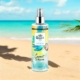 Une bouteille de Brume Coconut Passion Body Splash sur une plage de sable avec une mer turquoise et un ciel bleu en arrière-plan. Mode Grande taille