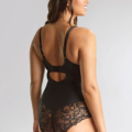 Le mannequin pose dos à l'appareil photo sur un fond neutre, mettant en valeur le body Body allure noir en dentelle. Mode Grande taille