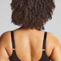 Une femme aux cheveux bouclés modèle le Soutien-gorge emboîtant Sophia en noir, présenté de dos sur un fond uni. Mode Grande taille