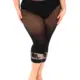 Une femme porte le modèle "Legging collants avec dentelle florale", un legging noir transparent avec des détails de dentelle florale près du mollet, alors qu'elle se tient pieds nus sur un fond blanc. Mode Grande taille