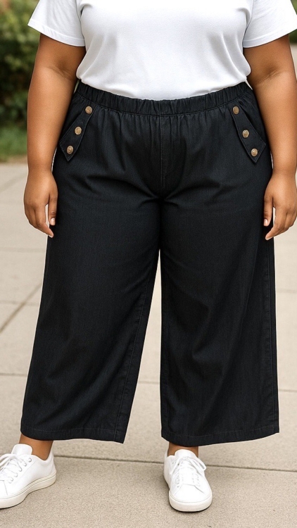 Personne portant le pantalon jambes larges avec boutons décoratifs, un t-shirt blanc et des baskets blanches, debout à l'extérieur. Mode Grande taille