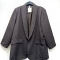 Le Blazer ouvert, un blazer noir avec deux poches sur le devant, est présenté sur un cintre sur fond blanc. Mode Grande taille