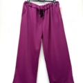 Le Pantalon décontracté en jersey est un pantalon large de couleur magenta avec une taille élastique et un cordon de serrage noir, présenté sur un cintre noir. Mode Grande taille