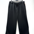 Pantalon décontracté en jersey à jambe large et taille à cordon, suspendu sur un cintre noir devant un fond blanc. Mode Grande taille
