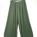 Pantalon jupe culotte plissé vert à jambes larges et plis, suspendu sur un cintre noir devant un fond blanc. Mode Grande taille