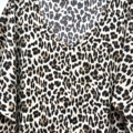 Gros plan sur la "Robe fluide manches bouffantes imprimé animalier", avec un motif léopard noir, marron et beige, suspendue à un cintre noir. Mode Grande taille