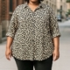 Une personne portant une Chemise imprimée animalier et un pantalon noir se tient sur un trottoir de la ville. Mode Grande taille
