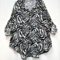 Chemise imprimée animalier à manches longues, coupe ample, avec motif zèbre noir et blanc suspendue sur un cintre. Mode Grande taille