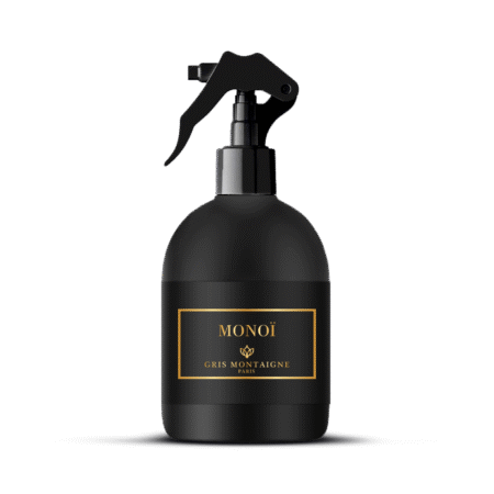 Flacon pulvérisateur noir étiqueté "MONOÏ Gris Montaigne Paris" avec une étiquette rehaussée d'or sur fond blanc. Mode Grande taille