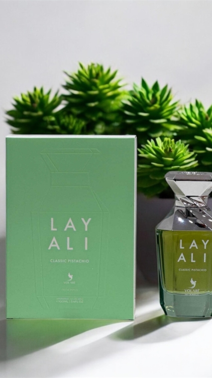 Un flacon et une boîte de parfum Layali Classic Pistachio présentés devant des plantes succulentes vertes. Mode Grande taille
