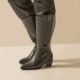 Bottes santiag mollets larges 3XL Thelma - Gabylou, en simili cuir noir à imprimé crocodile, talons blocs et détails cloutés, portées sur un pantalon noir. Mode Grande taille