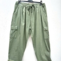 Pantalon cargo en coton super stretch de couleur vert clair, taille à cordon, poches latérales et bas retroussés, suspendu sur un cintre noir. Mode Grande taille