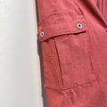 Gros plan de la poche à rabat boutonnée du Pantalon cargo en coton super stretch de couleur rouge, sur fond blanc. Mode Grande taille