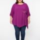 Blouse grande taille magenta col rond avec boucle dorée, portée par une femme ronde