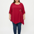 Blouse grande taille rouge framboise col rond avec boucle dorée, portée par une femme ronde
