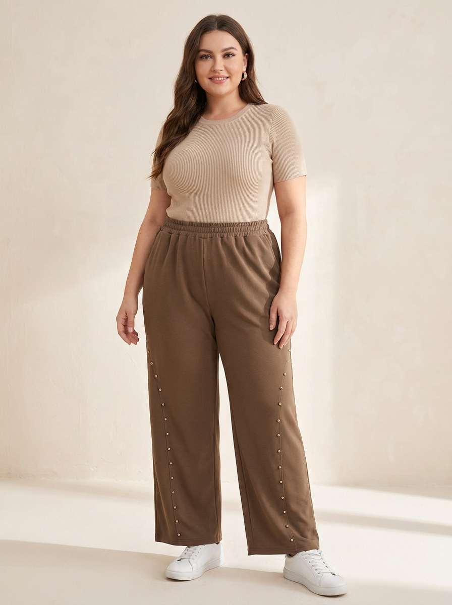 Pantalon large à clous dorés grande taille marron porté par une femme ronde