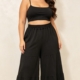 Pantalon large grande taille noir à volants étagés, taille élastiquée, porté par une femme ronde