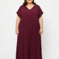 Robe longue plissée grande taille bordeaux à col V, portée par une femme ronde