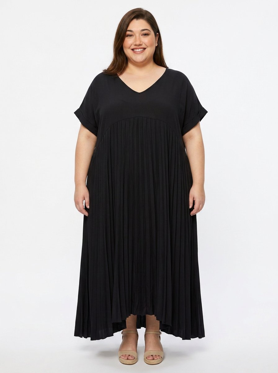 Robe longue plissée grande taille noire à col V, portée par une femme ronde