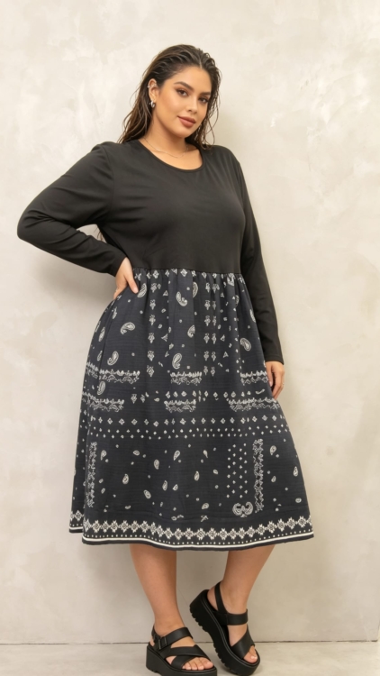 Robe midi grande taille noire à imprimé cachemire, buste uni et jupe froncée, portée par une femme ronde